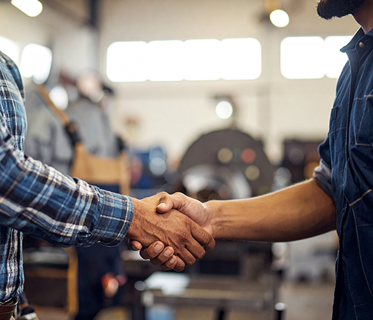 Poignée de main dans un atelier industriel.