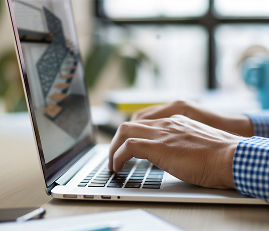 Personne tapant sur un ordinateur portable.