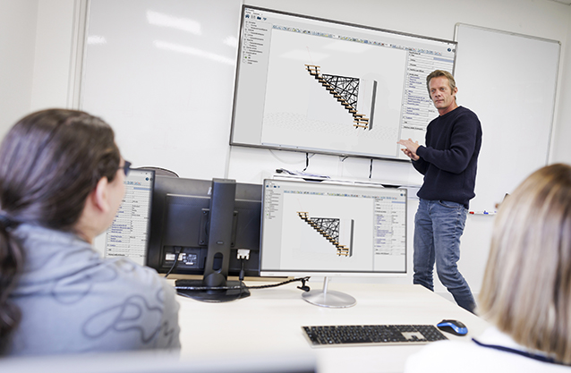 Enseignant explique un projet de construction sur écran.